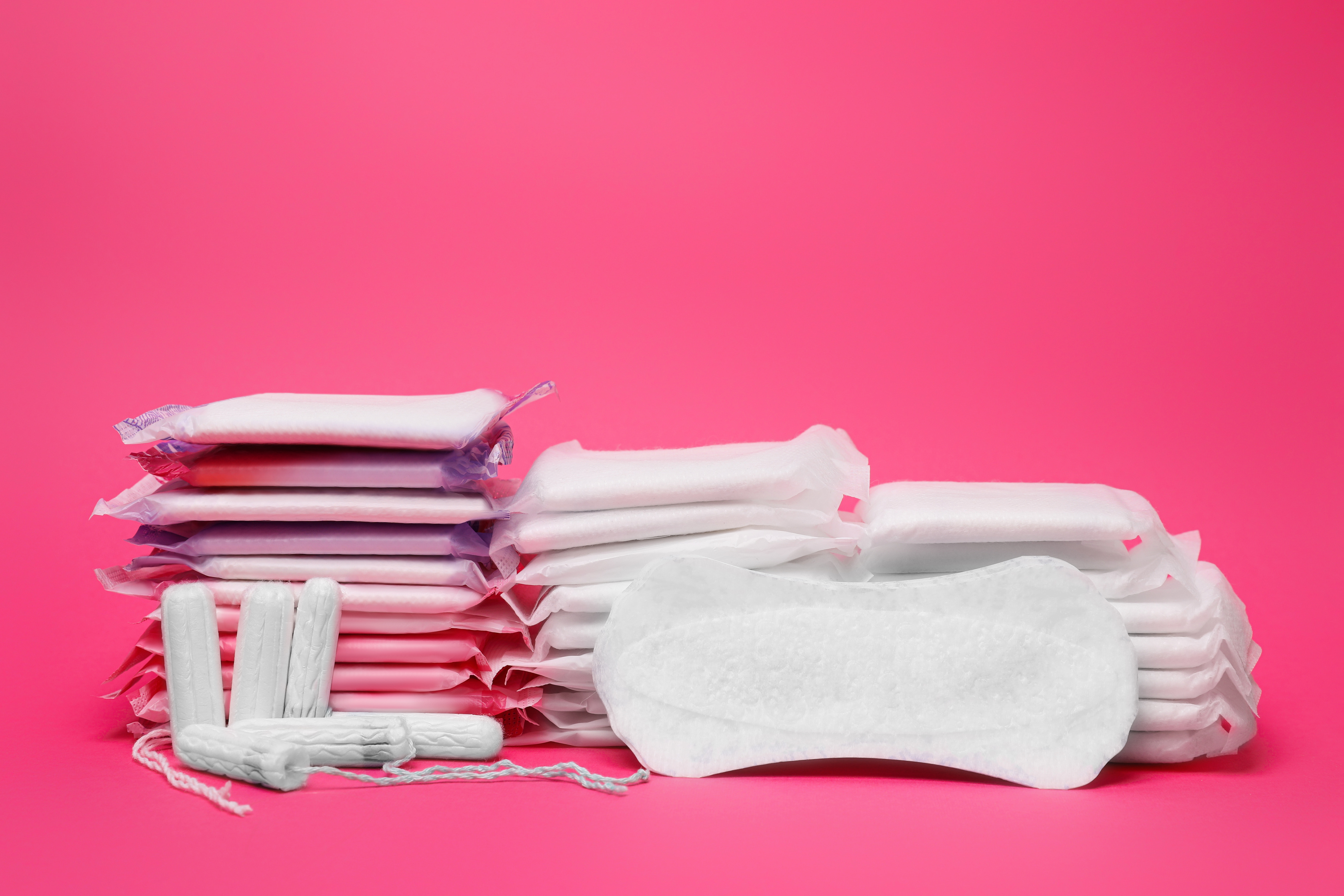 Many Menstrual Pads and Tampons on Pink Background